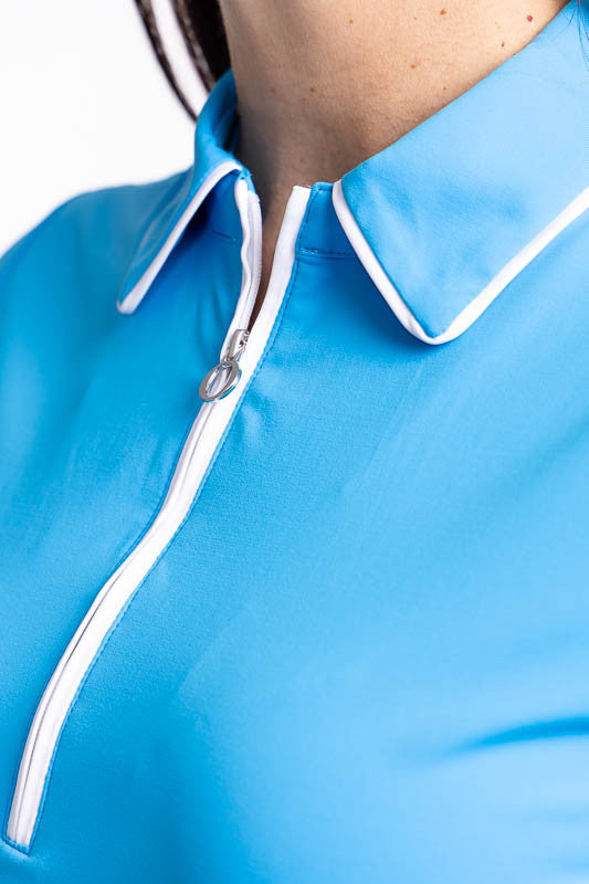 Close front view of the collar and front zip on the Prettier Than A Polo Short Sleeve Golf Top in Pacific Blue. This is a solid blue top with white piping on the collar and a white front quarter zip.