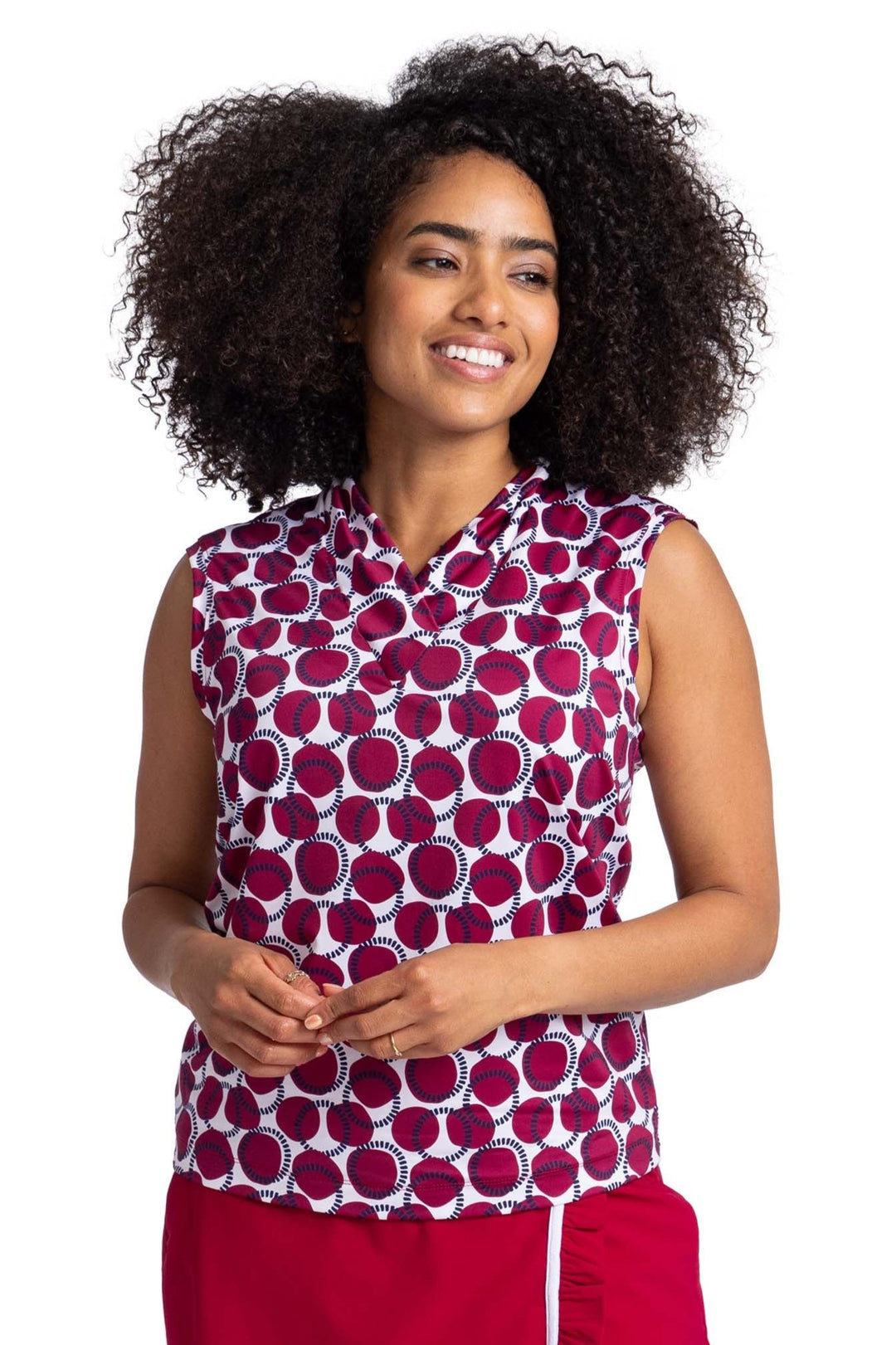 Front view of a woman wearing a sleeveless, V-neck top with Bordeaux Red and navy blue circles on a white background pattern.