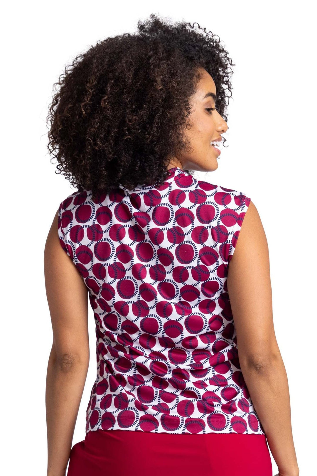 Back view of a woman wearing a sleeveless, V-neck top with Bordeaux Red and navy blue circles on a white background pattern. 