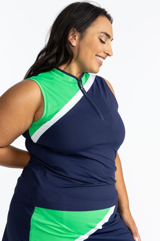 Right side and front view of the Tend the Flag Sleeveless Golf Top in Navy Blue. This top features a navy blue background with a diagonal white stripe and a section of Kelly green from the top of the left shoulder down to just below the bust on this top. 