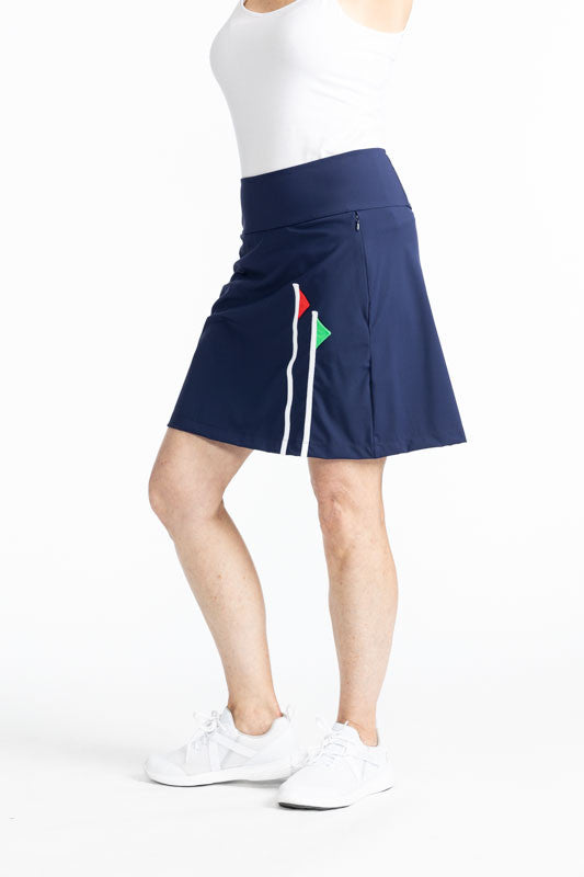 Full right side view of the Flagstick Golf Skort in Navy Blue. This skort is a solid navy blue with two golf flagsticks on the front left side - one is a red flag and the other is a green flag. 