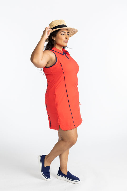 Right side view of the In The Cup Sleeveless Golf Dress in Tomato Red. This dress has black accents around the collar and down the front quarter zip, around each armhole, and one black line down each side on the front of this dress. 