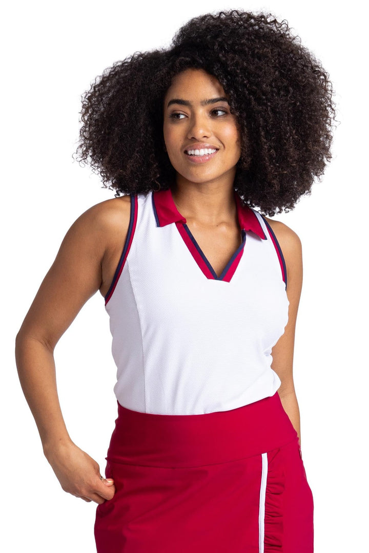 Image of a women wearing white racerback top with contrasting navy blue and Bordeaux red binding on the armholes and neckline. The top has a Bordeaux red collar.