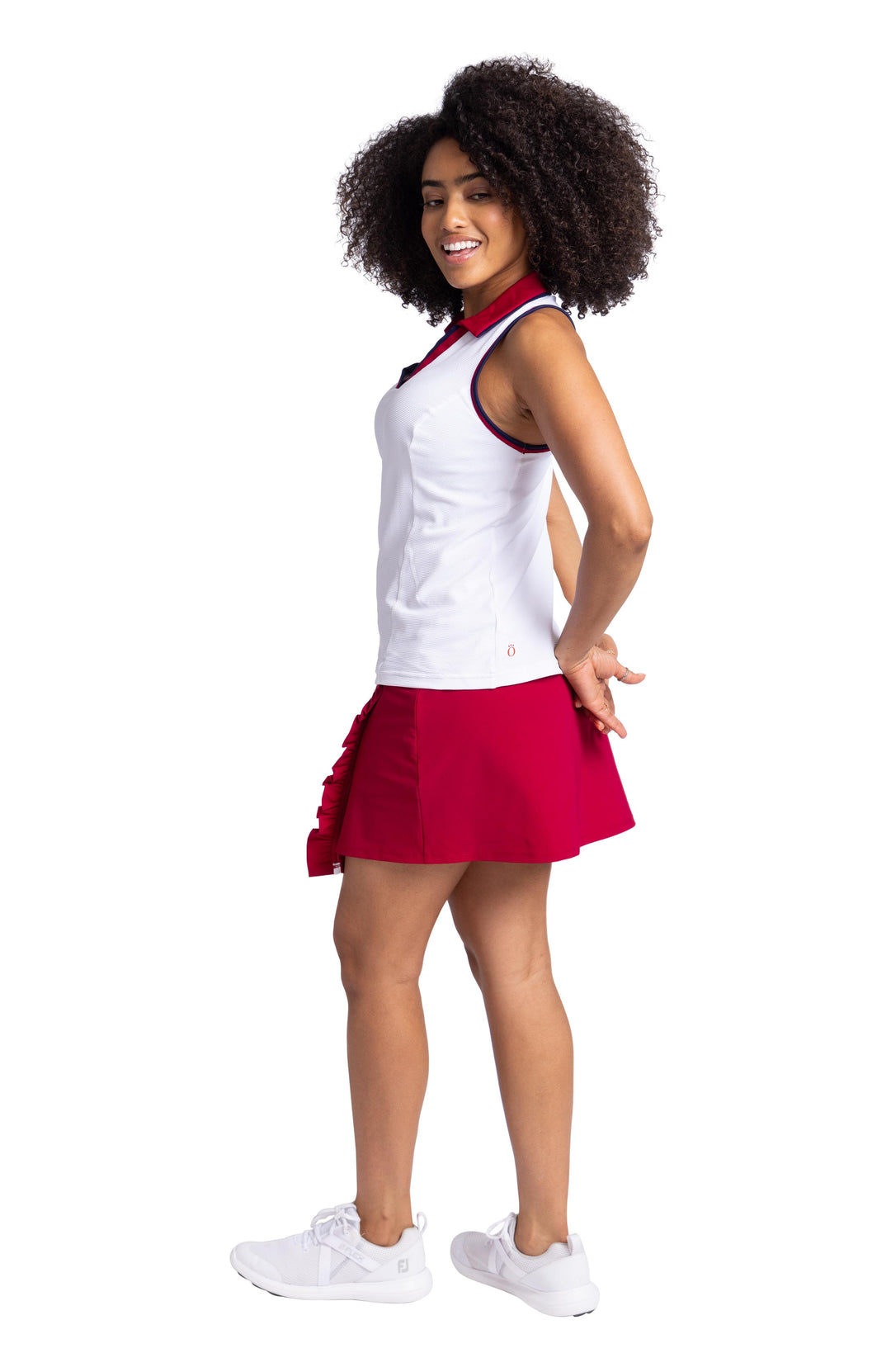 Side view of a women wearing white racerback top with contrasting navy blue and Bordeaux red binding on the armholes and neckline; and a Bordeaux red collar. The top is paired with the Ruffle in the Rough Skort in Bordeaux Red.