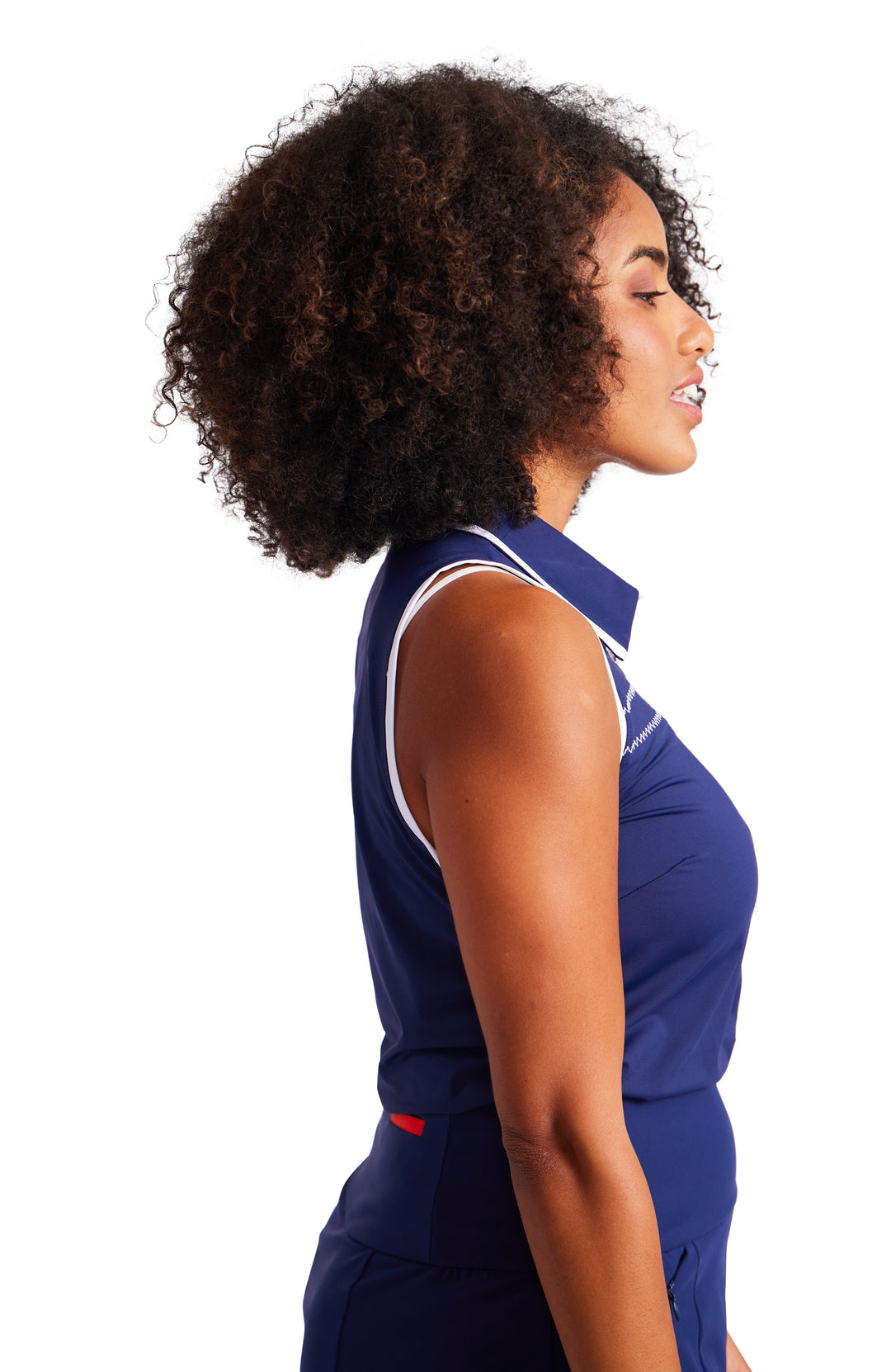 Side view of woman in navy sleeveless top with white trim on collar and armhole