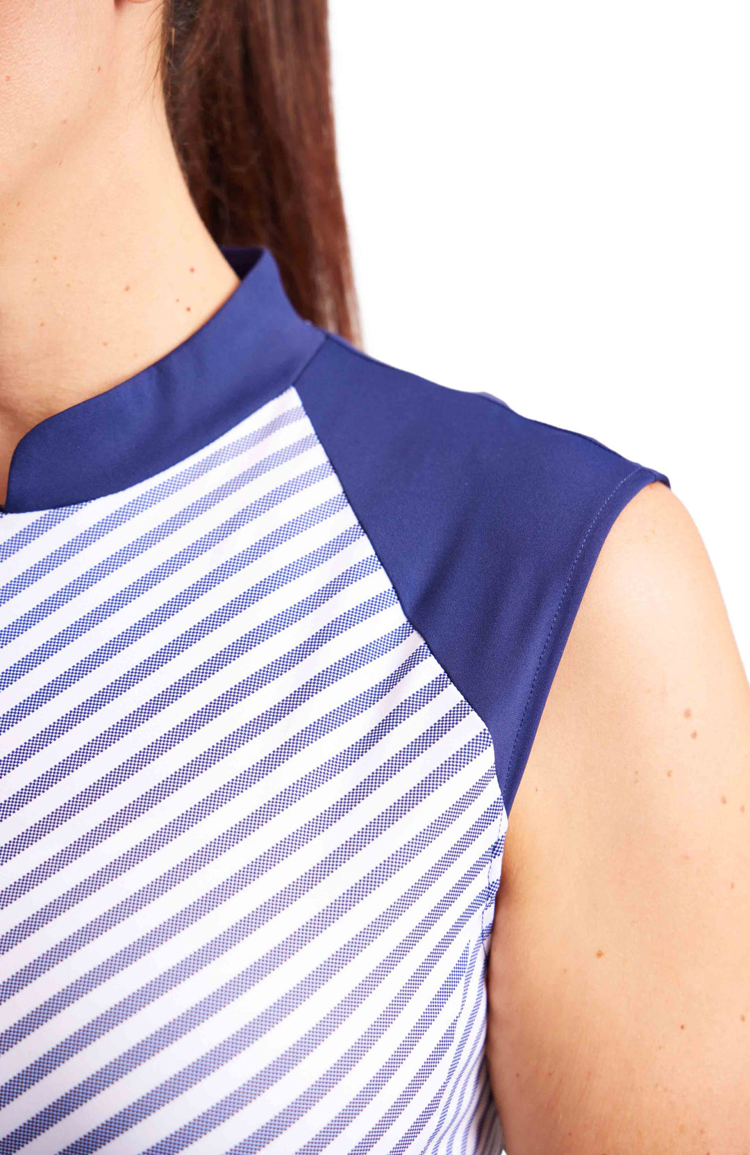 Close up view of woman in sleeveless top with blue and white stripe, navy shoulder and collar trim