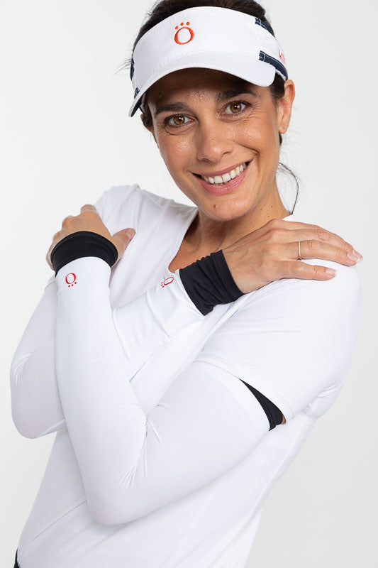 Smiling woman golfer wearing a No Hat Hair Visor in white, a white Tee It Up Golf Top, and a pair of Sun's Out Golf Sleeves in Black 