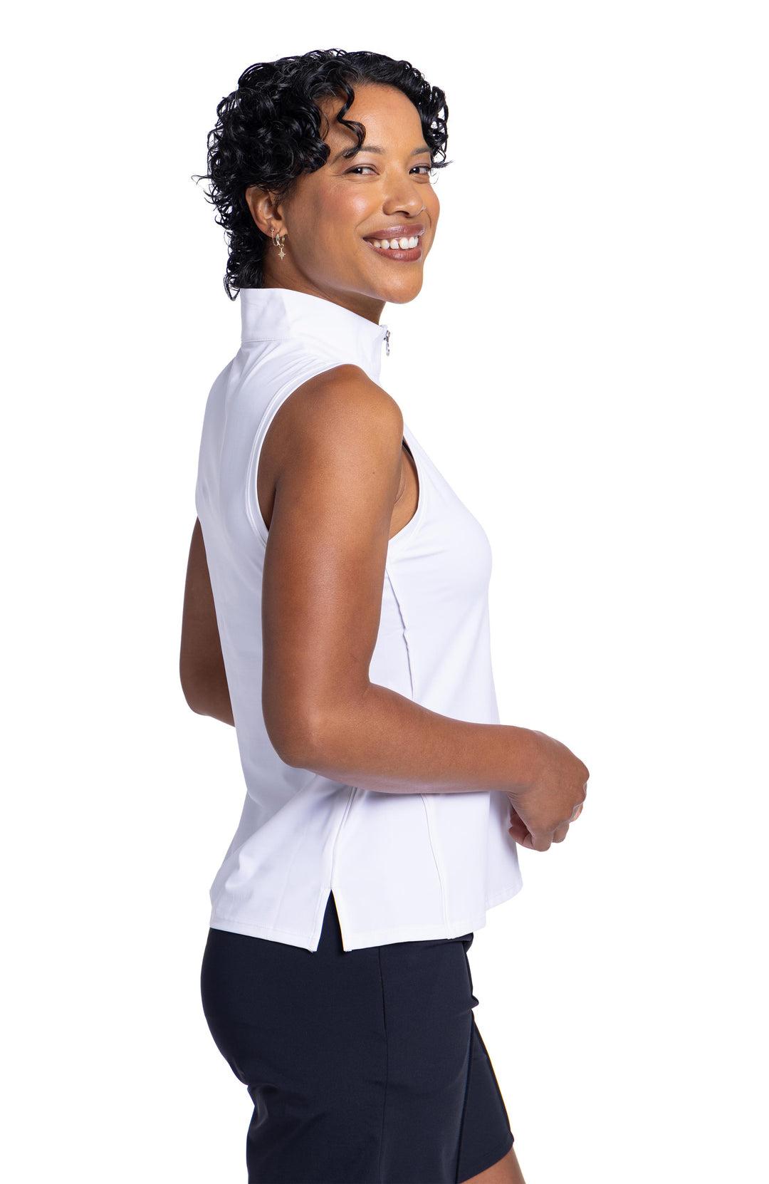 Side view of a woman looking over her shoulder wearing the Keep It Covered Sleeveless golf top and black Golf Glove Friendly short. 