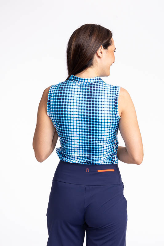 Back view of the Keep It Covered Sleeveless Golf Top in Ocean Plaid. The ocean plaid print is a vertical repeating gradient white to blue checkered print. The top features a white quarter zip front and two white stripes running down the side.