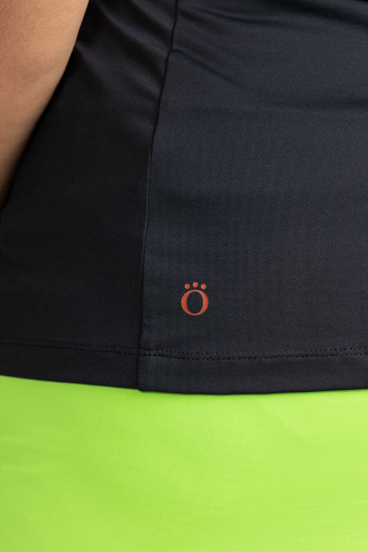 Close left side view of the hemline on the Twist and Shout Sleeveless Golf Top in Black. 