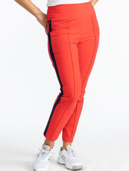 Close front view of the Tailored Track Golf Pants in Tomato Red. These pants are solid tomato red with a black stripe that runs down each side of the pants. There are also black accents on the two back pockets.