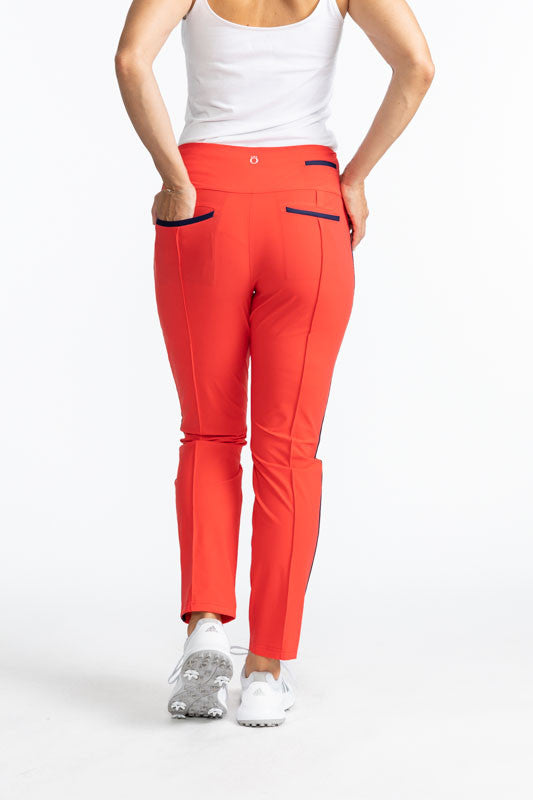 Full back view of the Tailored Track Golf Pants in Tomato Red. These pants are solid tomato red with a black stripe that runs down each side of the pants. There are also black accents on the two back pockets.