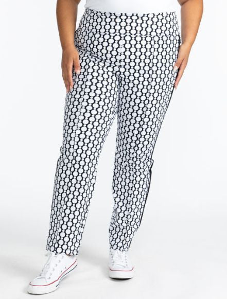 Close front view of the Tailored Track Golf Pants in Spiral Floral. This print is a retro-inspired abstract black and white flower pattern. There is one black stripe that runs the length on each side of these pants.