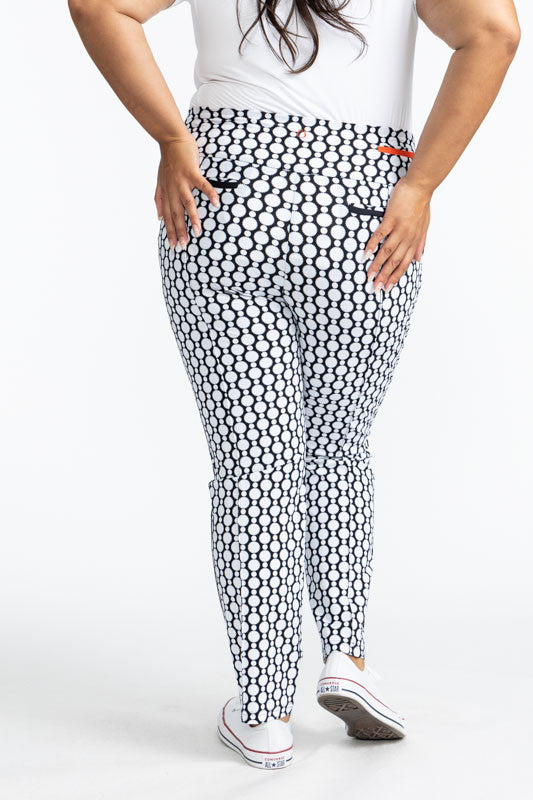 Full back view of the Tailored Track Golf Pants in Spiral Floral. This print is a retro-inspired abstract black and white flower pattern. There is one black stripe that runs the length on each side of these pants.