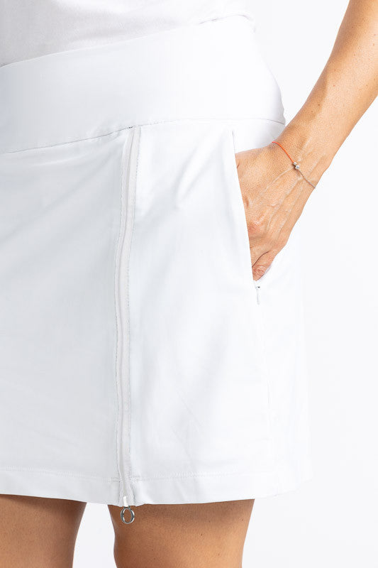 Close left front and side view of one of the in-seam pockets on the Summer Sass Golf Skort in White/White. This is a solid white skort with a 3/4 zipper on the front left side. 