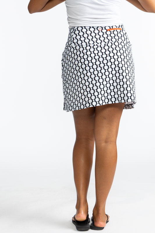 Full back view of the Swing and Swirl Golf Skort in Spiral Floral print. This print is a retro style black and white floral pattern. This skort has three black panels tucked in between the front panels of this skort.