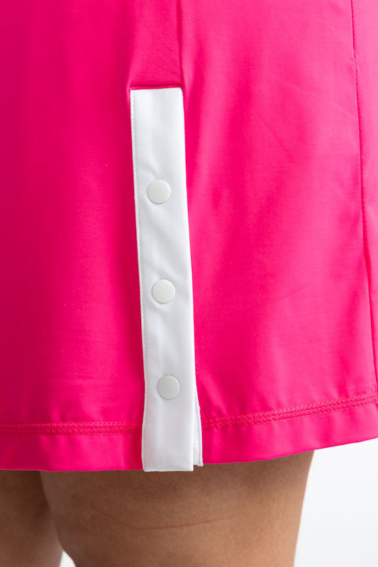 Close front left side view of the snaps and white stripe behind it on the Around the Green Golf Skort in Preppy Pink. This is a solid pink skort with three snaps with a white strip behind them on the front left side.