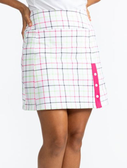 Close front view of the Around the Green Golf Skort in Tattersall Plaid. This skort has three snaps on the front left side with a stripe of Preppy Pink behind them. The Tattersall Plaid print is a white background with lines of Preppy Pink, Grass Green, a