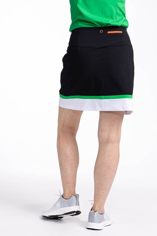 Back view of the In Play Golf Skort in Black/Green. This is a predominantly black skort with a thin band of green followed by a wide band of white at the bottom of the skort.