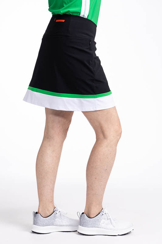 Right side view of the In Play Golf Skort in Black/Green. This is a predominantly black skort with a thin band of green followed by a wide band of white at the bottom of the skort.