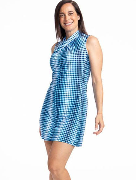 Close front view of the Twist and Shout Sleeveless Golf Dress in Ocean Plaid. The ocean plaid print is a vertical repeating gradient of white to blue checkered print, while the shift-style dress features a twisted neckline, back zipper, and zippered in-se