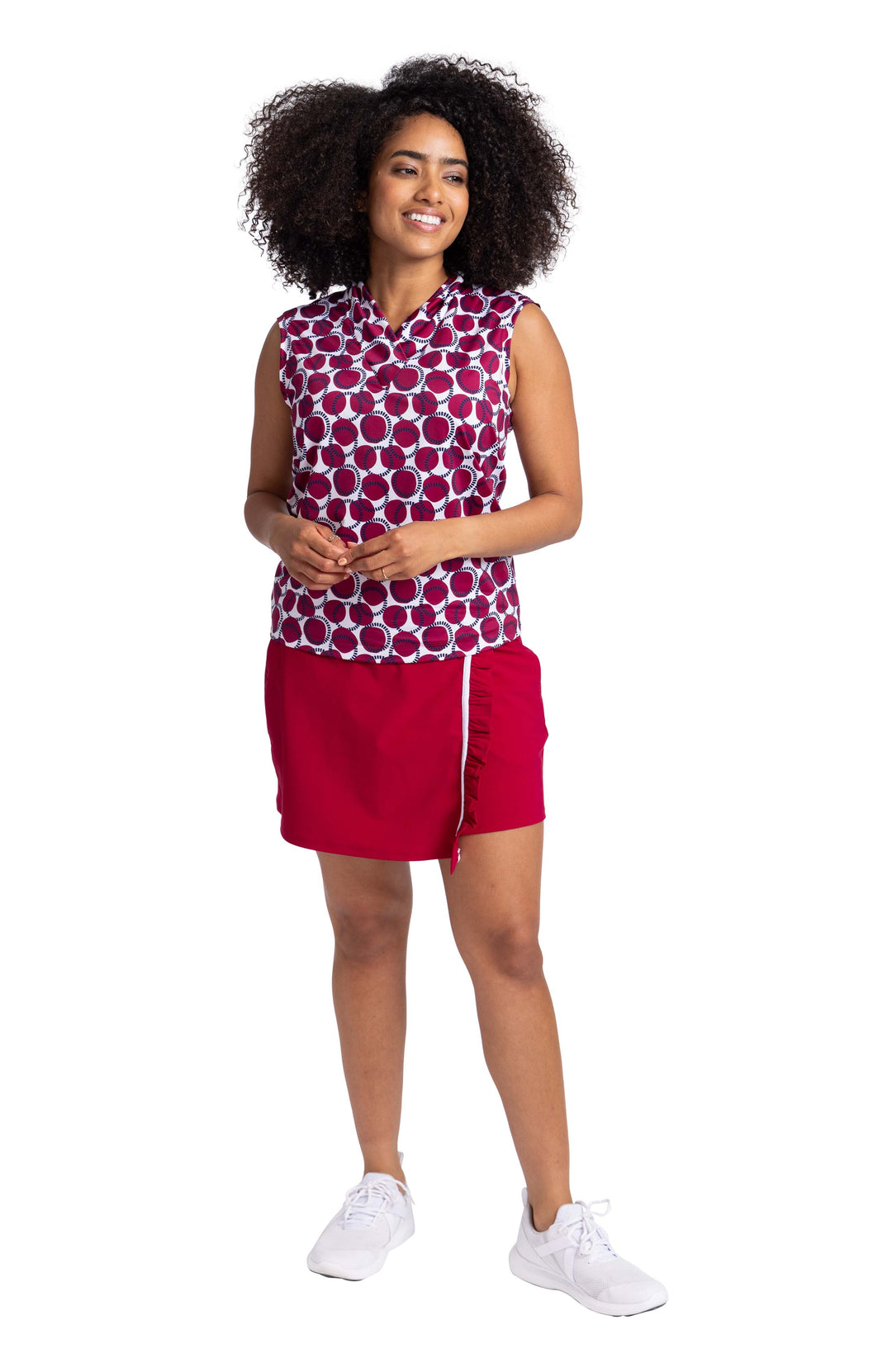 Full front view of a woman wearing the Light and Lovely Sleeveless Top in the Dot and Dash print paired with the Ruffle In The Rough Skort in Bordeaux Red.